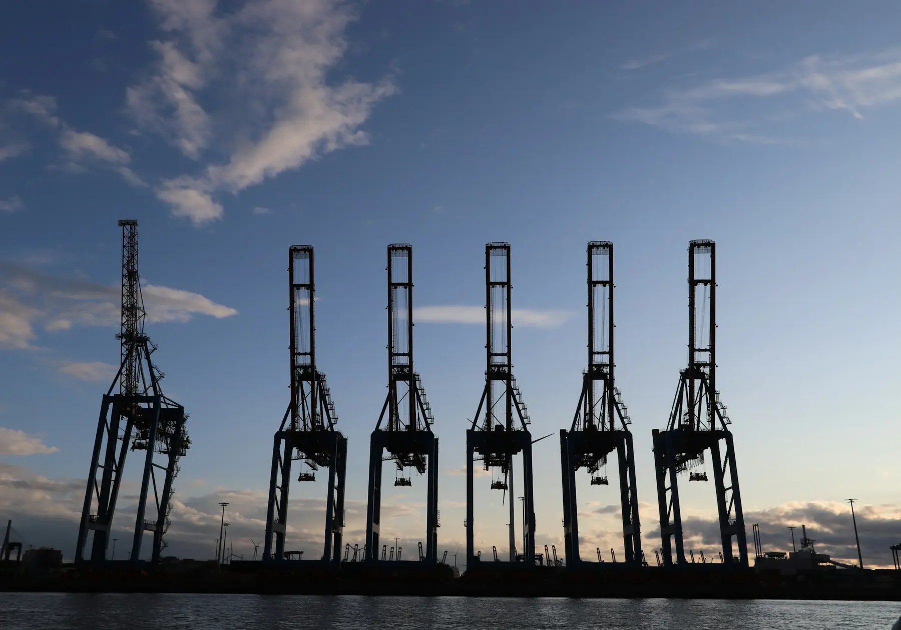 Container cranes silhouetted against the sky