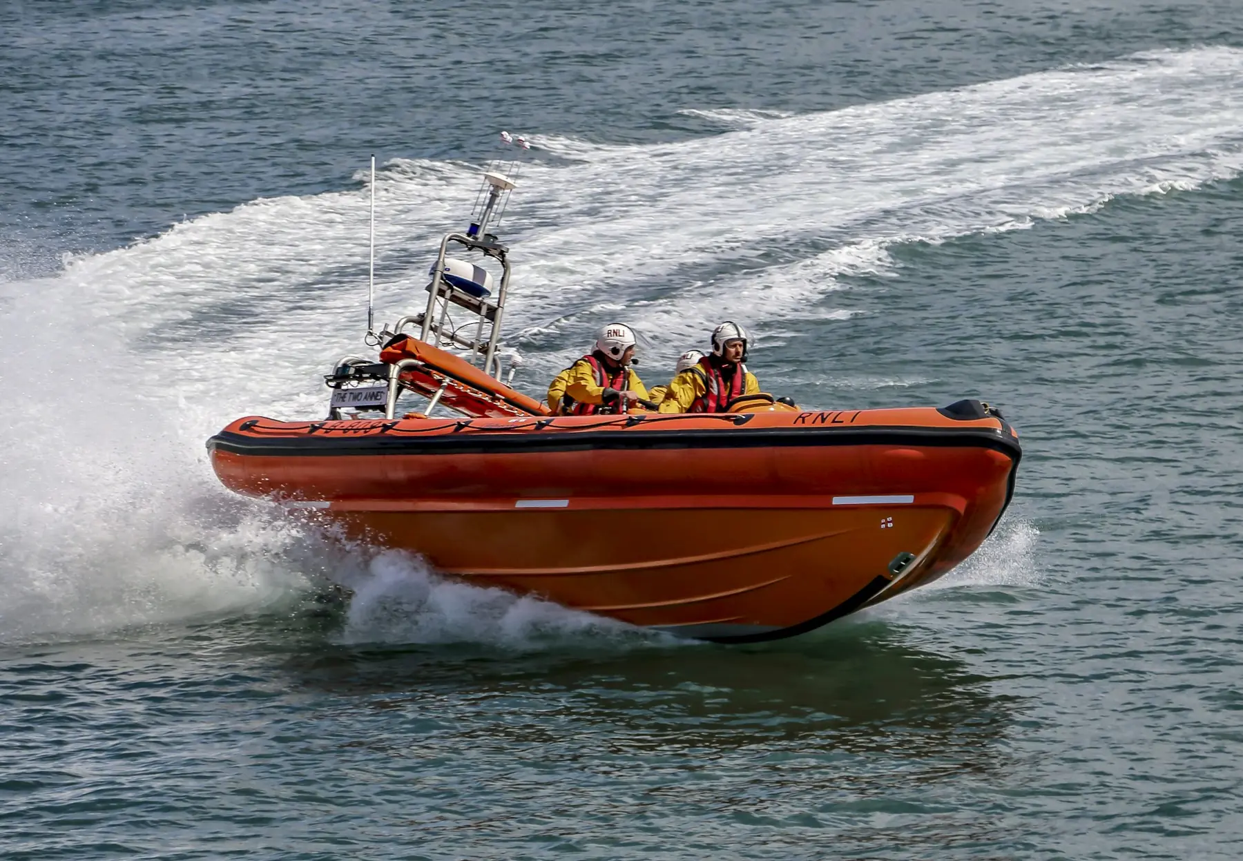 A rescue boat at speed throwing spray